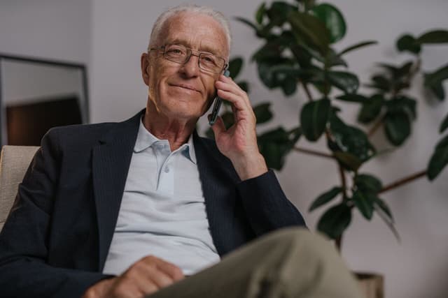 Elderly man talking on phone about a 401(k) gold IRA rollover