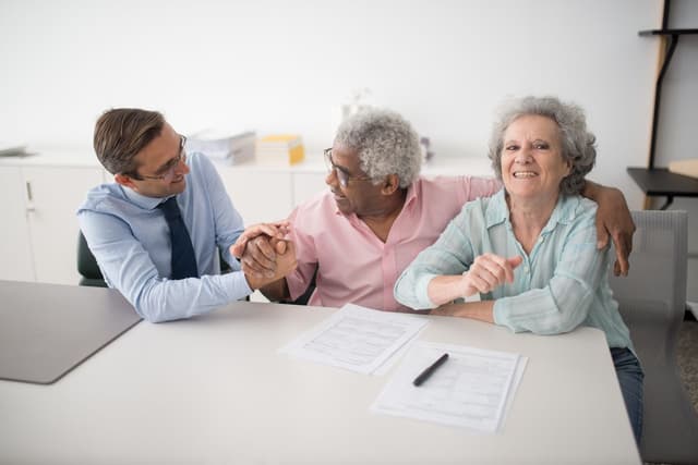 Precious metals specialist explaining gold IRA retirement strategies to elderly couple
