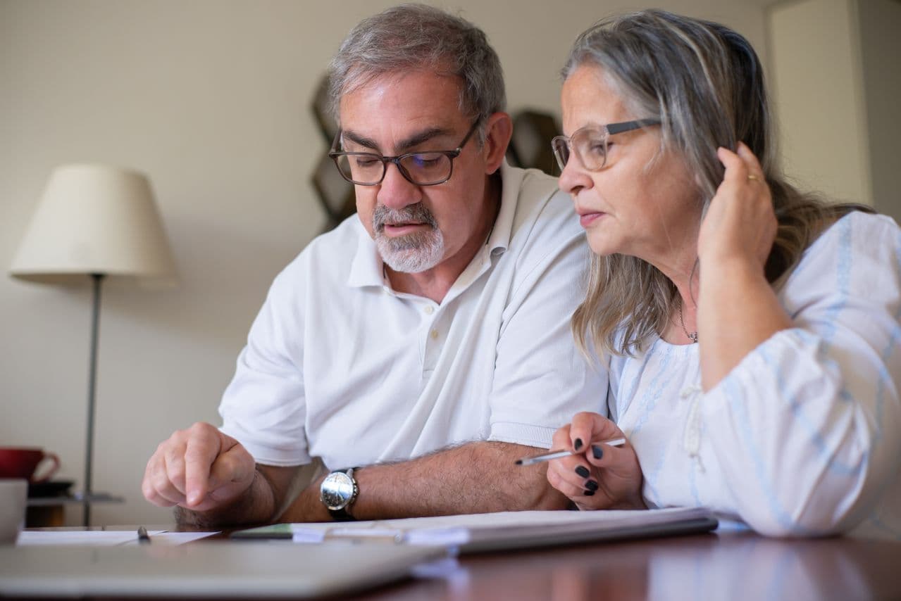 Elderly couple reviewing gold IRA eligibility requirements