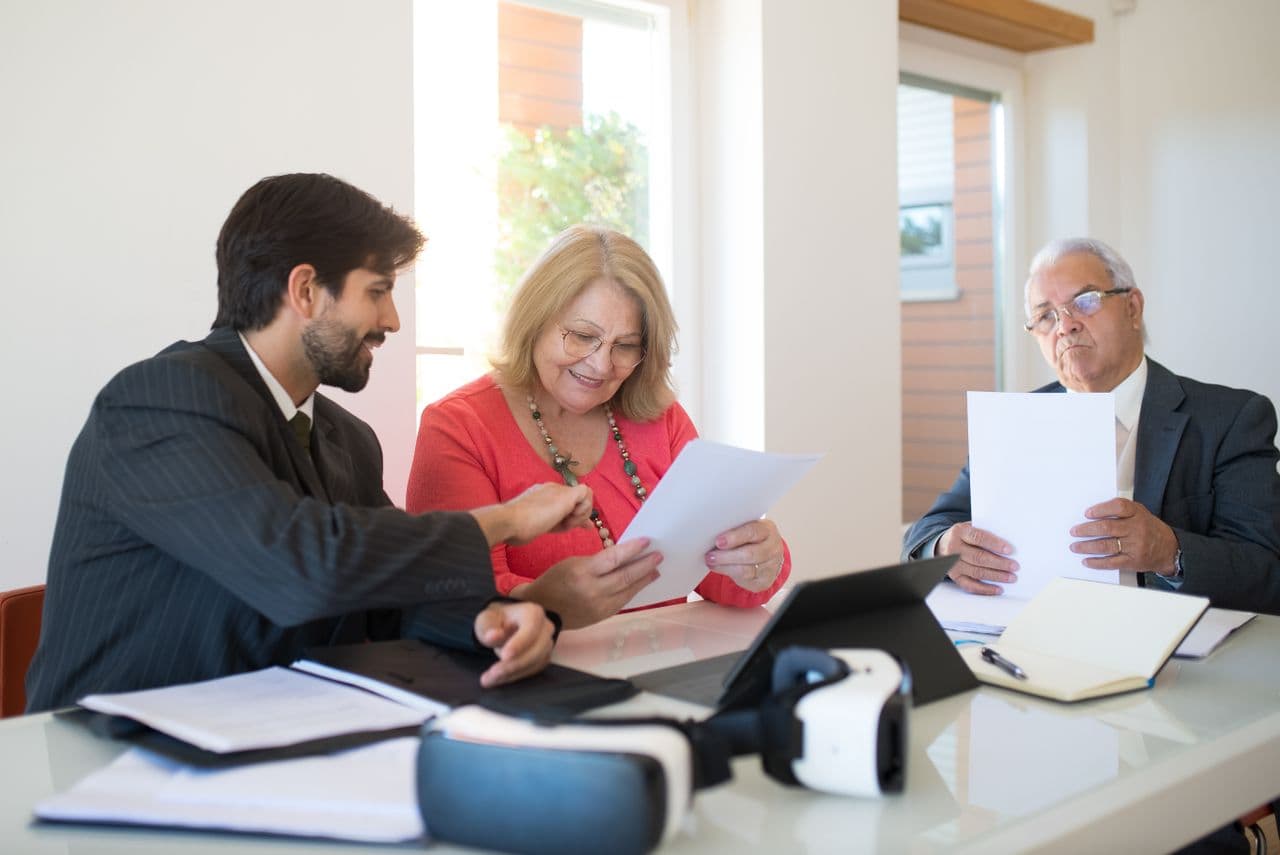 Elderly couple discussing gold investment strategies with a precious metals specialist