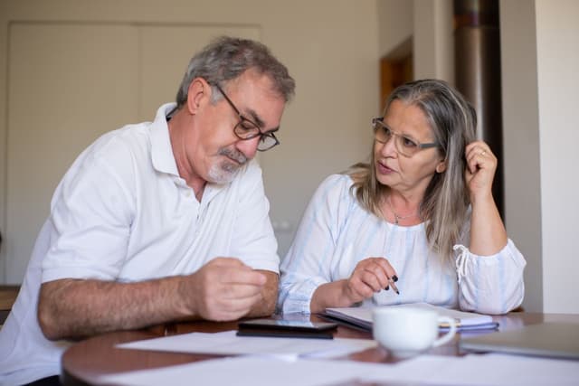 Elderly couple weighing gold IRA pros and cons