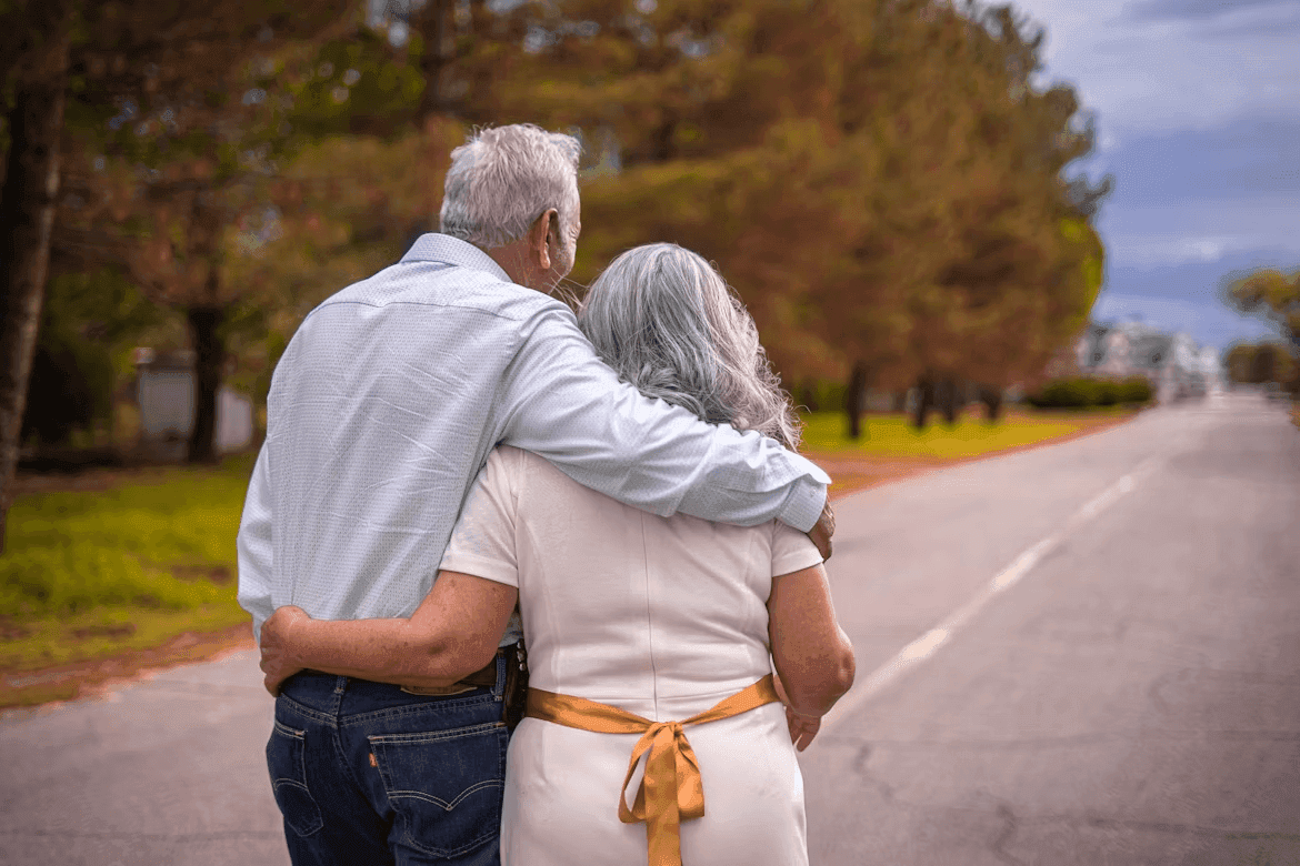 Elderly couple walking down a road